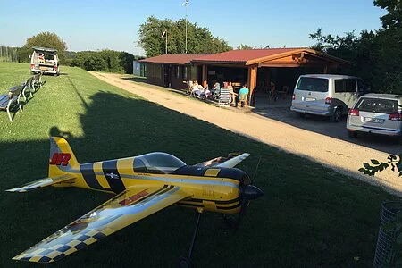 Gelbes Modellflugzeug am Sportplatz.