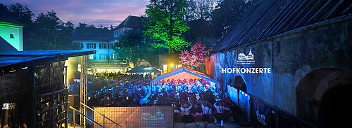 Hofkonzert Schloss Syburg Abendliche Außenaufnahme eines beleuchteten Konzertpublikums bei den Hofkonzerten im Schloss Syburg.
